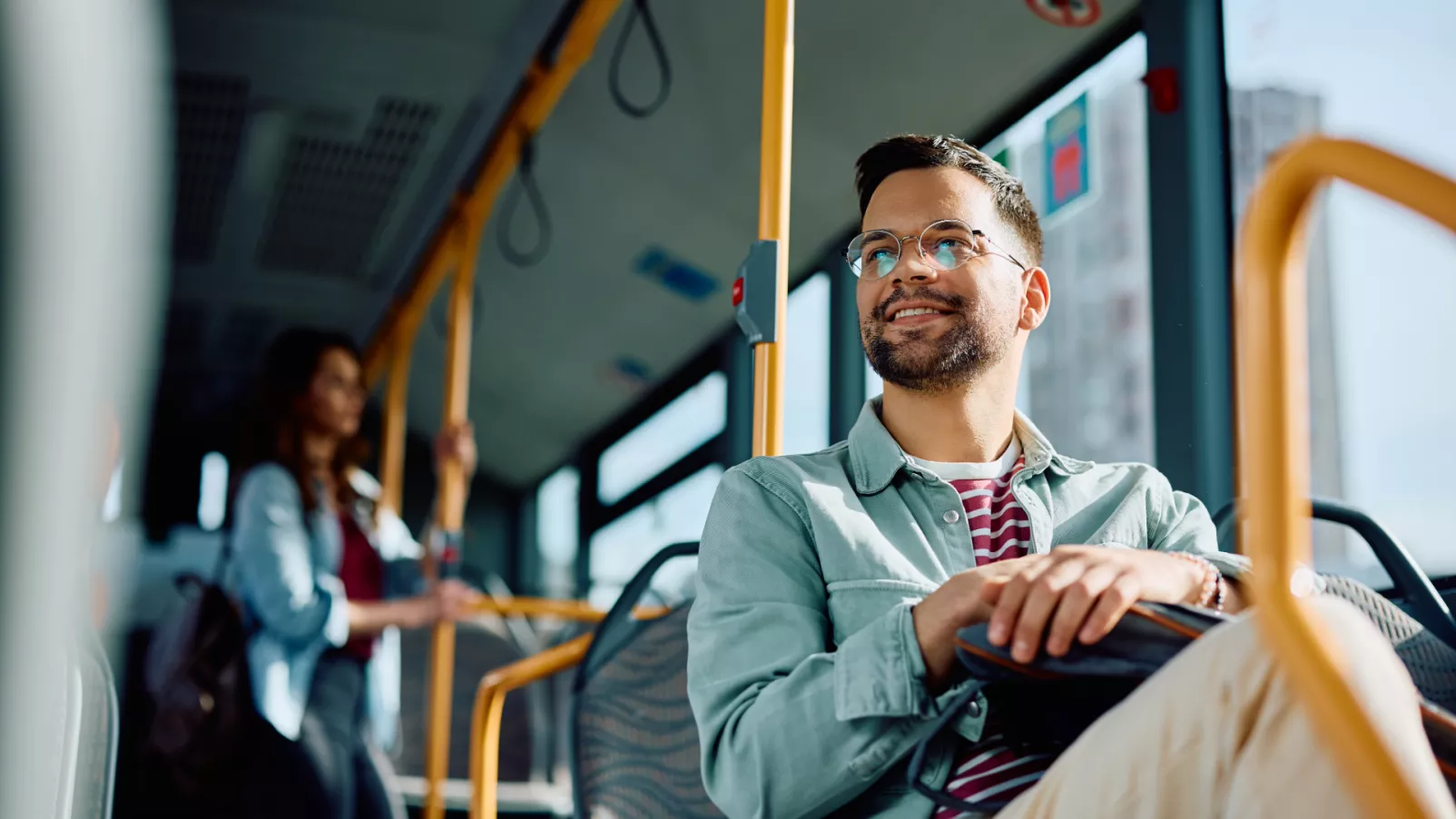 Mann sitzt in einem Bus auf dem Weg zur Arbeit