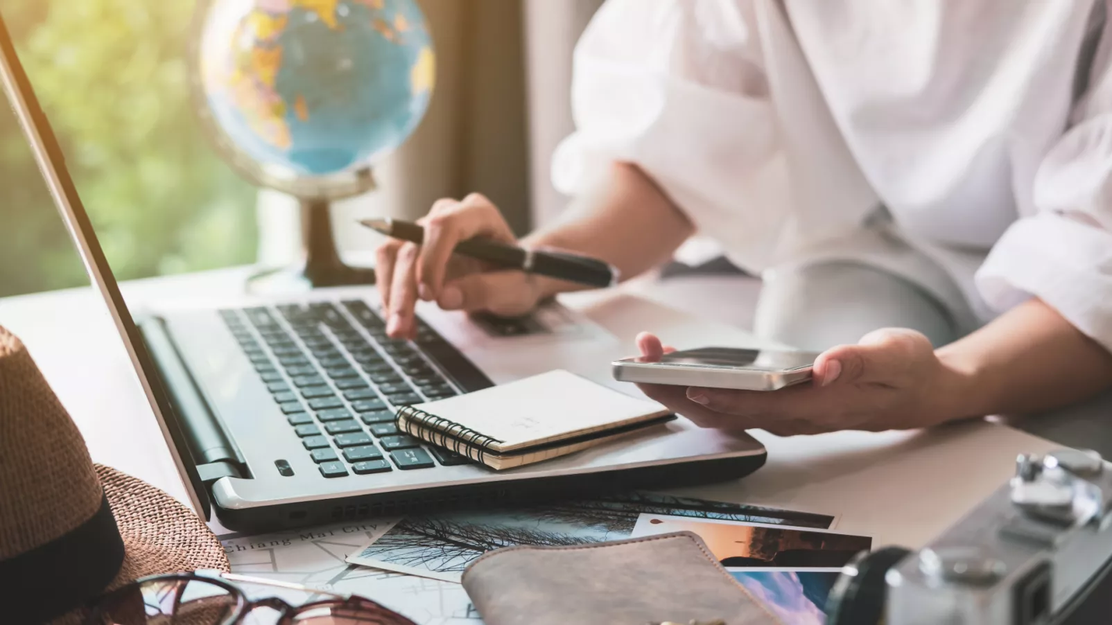 Person plant ihren Urlaub an Computer und Telefon