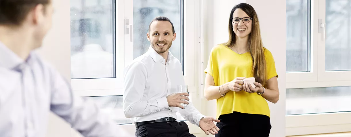 Das Bild zeigt VZ-Mitarbeiter während einer Unterhaltung in der Cafeteria.