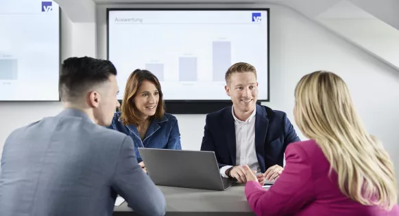 Mehrere Personen an einem Tisch in einem Gespräch vertieft