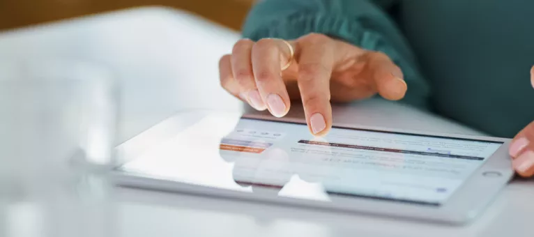 Das Bild zeigt eine Frauenhand, die einen Bewerbungsprozess am Tablet durchführt.